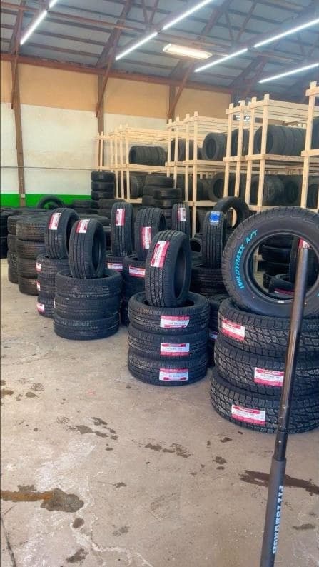 Stacks of new all-terrain and passenger tires with size labels
