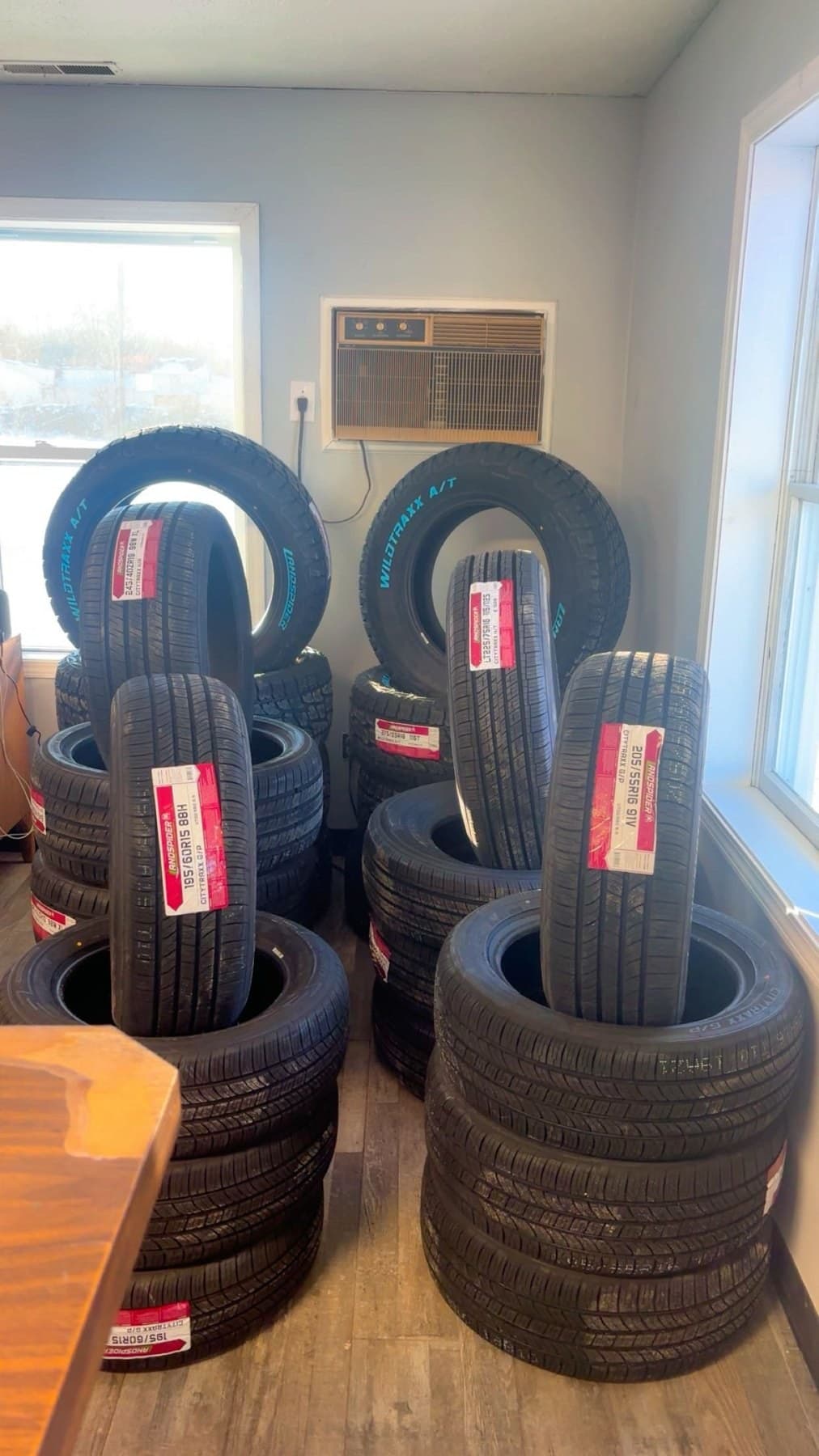 New tires with size labels stacked in the Speedy Tires front office